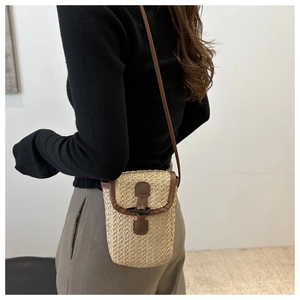 Detail shot of the woven texture and retro horn buckle on a stylish summer crossbody bag