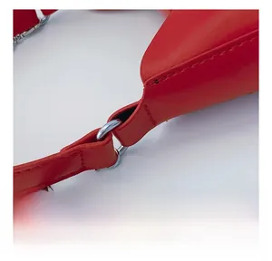 Detail shot of the silver metal ring connector and chain on the red leather handbag