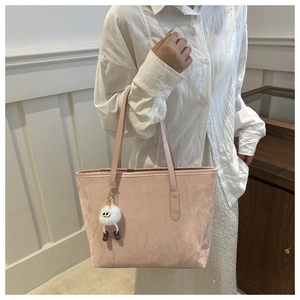 Pink tote bag detail with crinkled texture and cute white monster plush pendant accessory