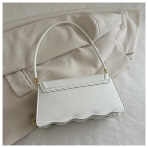 Dettaglio della base ondulata e della tasca posteriore di questa borsa a spalla in pelle PU