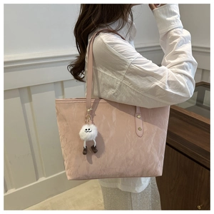 Detail of pink tote bag with pleated cloud texture and white plush charm on model