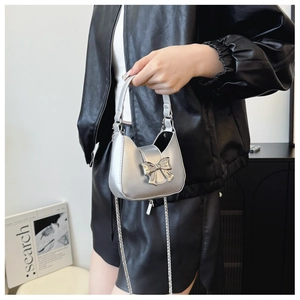 Detailed shot of silver mini handbag with metallic bow and detachable chain strap