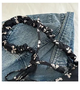 Detail of floral patterned pleated fabric handle with romantic time text on denim