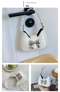 Detailed views of a mini cream-white handbag featuring a large silver metal bow accent