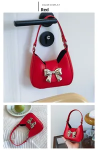 Detailed views of the red crescent handbag featuring a large silver metal bow accessory