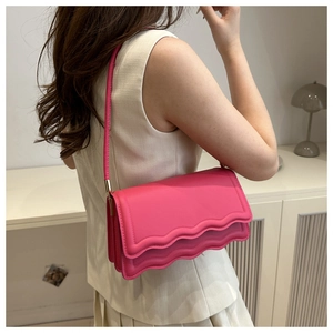 Detail der rosafarbenen Schultertasche mit wellenförmiger Naht und mattem Leder-Finish
