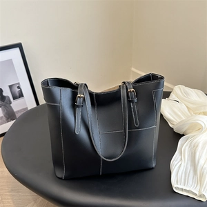 Black large tote bag with white contrast stitching and adjustable leather straps for women