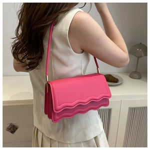 Détail du sac à bandoulière en cuir rose avec bords ondulés et boucles en métal doré