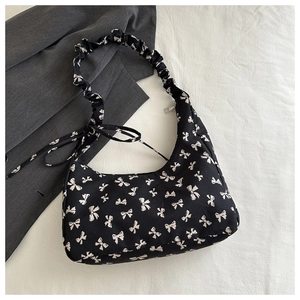 Detail of floral hobo bag with white bow print and stylish gathered shoulder strap