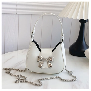 Detail of white half-moon mini bag with silver bow buckle and elegant metal chain strap