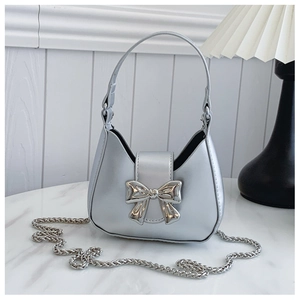 Close-up of metallic silver hobo bag with large bow buckle and sleek chain strap