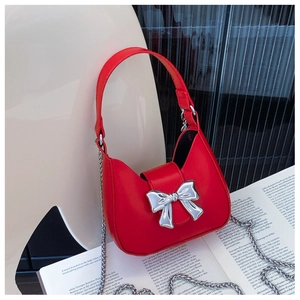 Detail of red crescent bag with silver bow buckle and delicate metal chain strap