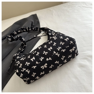 Detail of floral canvas tote with white bow patterns and pleated cloud shoulder strap