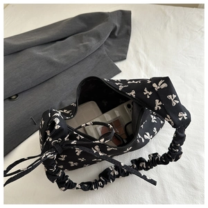 Detail of black bow print tote showing internal space for phone and cosmetics
