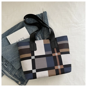 Vue de dessus d'un grand sac cabas à carreaux sur denim avec large bandoulière en nylon