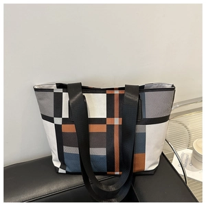 Détail d'un sac cabas en toile à motifs géométriques colorés dans un cadre urbain