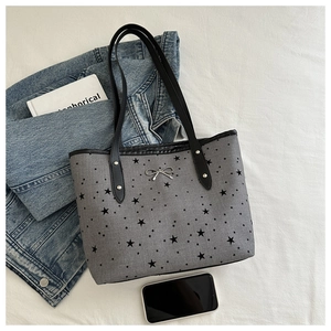 Vista dall'alto di borsa tote in tela con stelle, fiocco metallico e decorazioni varie