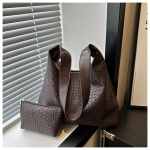 Detail of brown woven texture tote bag with matching inner pouch on a modern set