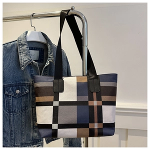 Détail du grand sac cabas à carreaux color-block en toile suspendu sur un support