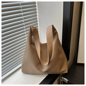 Close-up of woven texture on khaki Hobo tote bag with soft natural light highlights