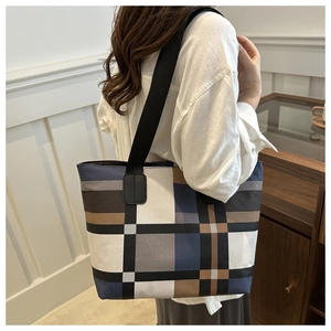 Détail du grand sac cabas géométrique color-block porté par un mannequin au style chic