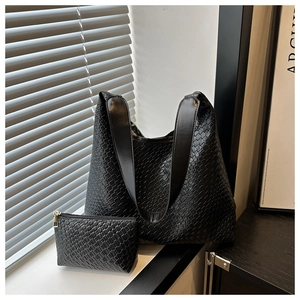 Detail shot of black woven leather tote bag with matching zippered coin purse