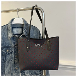Dettaglio della borsa shopper grigia con cuori rossi e fiocco in metallo argento