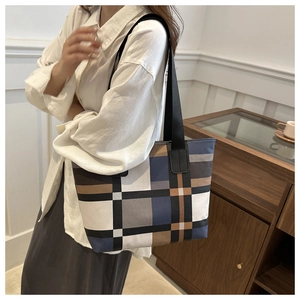 Sac fourre-tout color-block moderne en bleu marine, marron et crème porté par un mannequin
