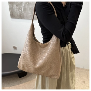 Detail of the woven texture and large capacity on the beige shoulder tote bag
