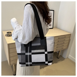 Détail du grand sac cabas à carreaux montrant la bandoulière large et le tissu épais