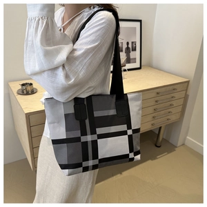 Détail du sac cabas à carreaux montrant les grands blocs de couleur noir, blanc et gris