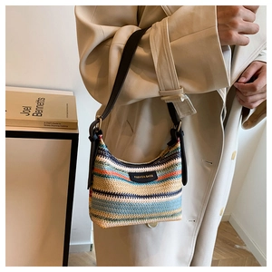 Detail of multi-color striped woven shoulder bag with leather patch and strap