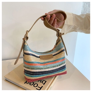 Detail of colorful rainbow striped straw underarm bag with leather strap and metal zipper