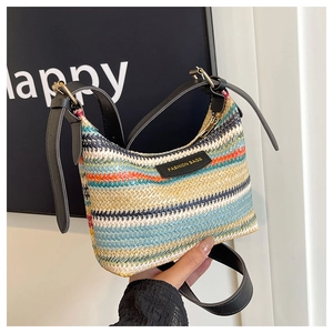 Detail of colorful rainbow striped woven shoulder bag with black leather strap and gold hardware