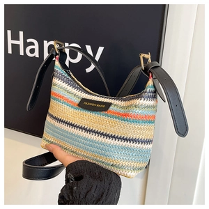 Close-up of rainbow striped straw shoulder bag with black leather tag and fashion text