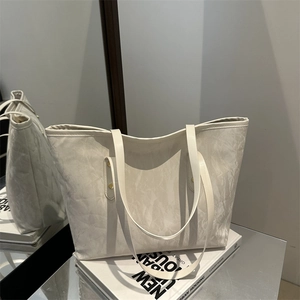 Chic beige textured tote bag with marble pattern on stylish art books for urban fashion