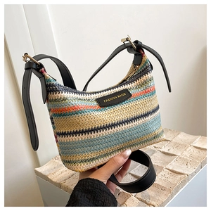 Close-up of bohemian rainbow striped woven shoulder bag with black leather strap detail