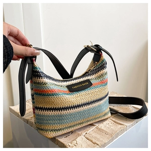 Detail of multi-color rainbow striped woven shoulder bag with leather logo patch