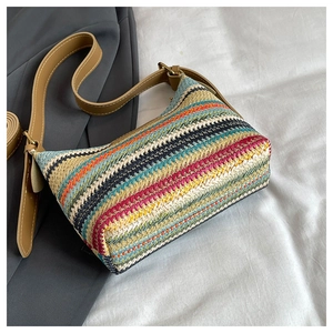 Detail view of colorful woven texture and striped geometric patterns on women's shoulder bag