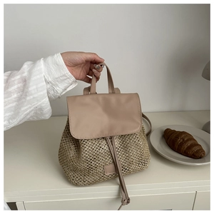 Dettaglio della trama dello zaino in paglia intrecciata con patta in pelle e coulisse