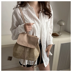 Detail of hand-woven straw texture and beige leather accents on a stylish backpack