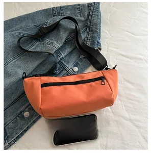 Detailed comparison of the compact orange crossbody bag next to a smartphone