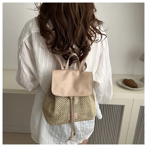 Close-up of woven beige summer backpack featuring drawstring closure and top handle