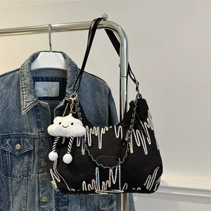 Detail of black canvas shoulder bag with wave embroidery and cute cloud charm