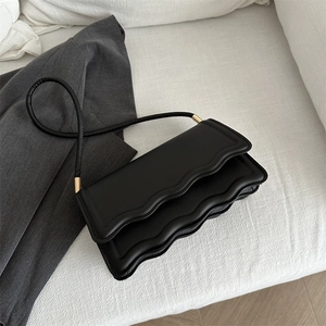 Sac à bandoulière noir minimaliste avec rabat ondulé et détails dorés élégants