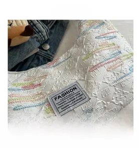 Close-up of quilted canvas tote with colorful embroidery and Fashion Instinct label
