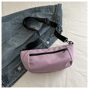 Close-up of purple nylon crossbody bag featuring adjustable black strap and metal buckle