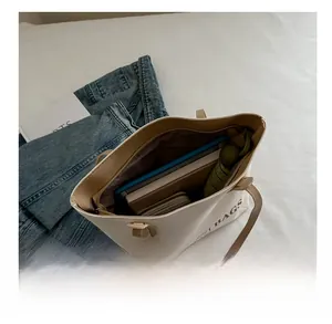 Top view of white canvas tote bag showing interior storage for tablet, books and umbrella