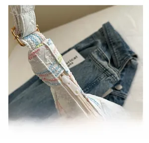 Detailed view of the smooth resin zipper and colorful embroidery on the white dumpling bag