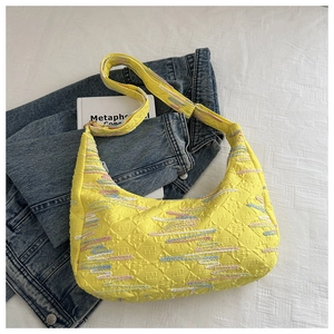 Detail of yellow nylon hobo bag with embossed FF pattern and colorful wavy stripes